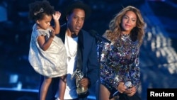 Jay-Z presents the Video Vanguard Award to Beyonce as he holds their daughter Blue Ivy during the 2014 MTV Video Music Awards in Inglewood, California Aug. 24, 2014.