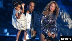 Jay-Z presents the Video Vanguard Award to Beyonce as he holds their daughter Blue Ivy during the 2014 MTV Video Music Awards in Inglewood, California Aug. 24, 2014.