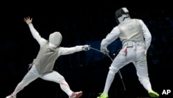 Suguru Awaji of Japan competes against Andrea Cassara of Italy, right, in the gold medal match during the men's foil team fencing competition at the 2012 Summer Olympics.