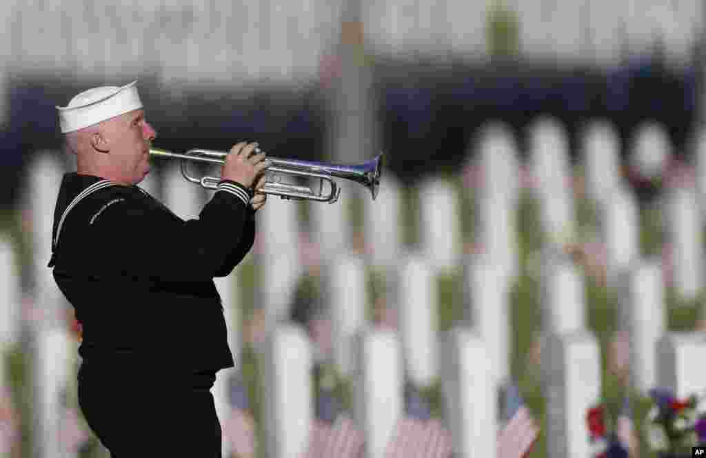 Pensiunan AL AS Mark Stallins dari Denver memainkan musik untuk para veteran di Taman Makam Pahlawan Fort Logan, 28 Mei 2017, di barat daya Denver, Colorado.