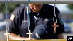 A police chaplain pays his respects July 18, 2016, at a makeshift memorial at the fatal shooting scene in Baton Rouge, Louisiana, where three law enforcement officers were ambushed and killed by a lone gunman on Sunday.