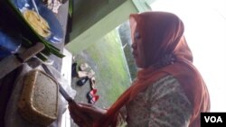 Seorang ibu anggota relawan Omaba sedang menyiapkan nugget tempe untuk makanan balita. (VOA/R. Teja Wulan)