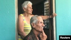 Miguel Barroz Lozano, 82, sits with his wife on the front porch of their farm house in rural Matanzas Province, Cuba, July 9, 2018. 