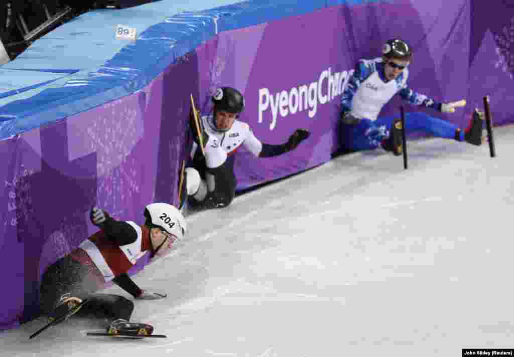 Ковзаняри Роберт Пукітіс з Латвії, J.R. Селский із США та олімпійський атлет з Росії Павло Ситніков впали під час чоловічого змаганя з Швидкісного шорт-треку (1000м - змагання з бігу на ковзанах) 13 лютого, 2018 року.