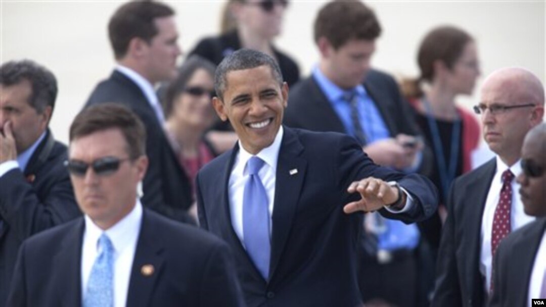 Obama melambai kepada para pendukungnya saat tiba di bandara Grand Rapids, Michigan (11/8)
