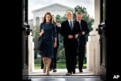 FILE - Judge Amy Coney Barrett, President Donald Trump's nominee to the Supreme Court, and Vice President Mike Pence arrive at the Capitol where she was to meet with senators, Sept. 29, 2020.