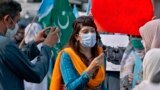 Mona Khan, seorang jurnalis perempuan lepas, melakukan wawancara saat demonstrasi, di Islamabad, Pakistan pada 2020. (Foto: AP)