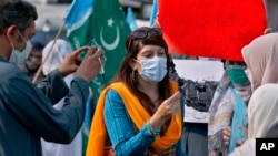 Mona Khan, seorang jurnalis perempuan lepas, melakukan wawancara saat demonstrasi, di Islamabad, Pakistan pada 2020. (Foto: AP)
