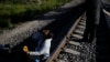Seorang migran asal Venezuela tampak menunggu di rel kereta api dengan harapan dapat menaiki kereta barang yang akan bergerak menuju Huehuetoca, Meksiko, pada 20 September 2023. (Foto: AP/Eduardo Verdugo)
