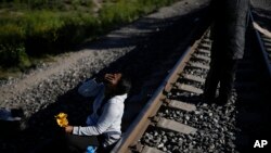 Seorang migran asal Venezuela tampak menunggu di rel kereta api dengan harapan dapat menaiki kereta barang yang akan bergerak menuju Huehuetoca, Meksiko, pada 20 September 2023. (Foto: AP/Eduardo Verdugo)