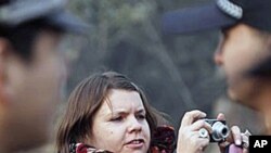 Karen Patterson of Canada, center, wife of Chinese artist Wu Yuren, takes pictures of her supporters after attending her husband's trial at the Wenyuhe Court in Beijing, 17 Nov 2010