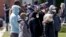 FILE - People line up for a free COVID-19 test in a parking lot in Milwaukee, Wisconsin, May 11, 2020. 