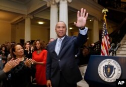 FILE - Massachusetts Gov. Deval Patrick, center, waves to people in the audience as his wife Diane Bemus, left, looks on at the conclusion of ceremonies for the unveiling of his official state portrait, Jan. 4, 2015, at the Statehouse, in Boston.