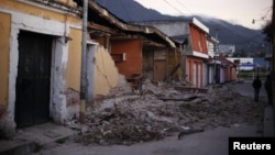 Two men walk past damaged houses after a 7.4-magnitude earthquake struck on the streets of San Marcos, about 250 km south of Guatemala City, November 8, 2012.