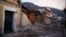 Two men walk past damaged houses after a 7.4-magnitude earthquake struck on the streets of San Marcos, about 250 km south of Guatemala City, November 8, 2012.