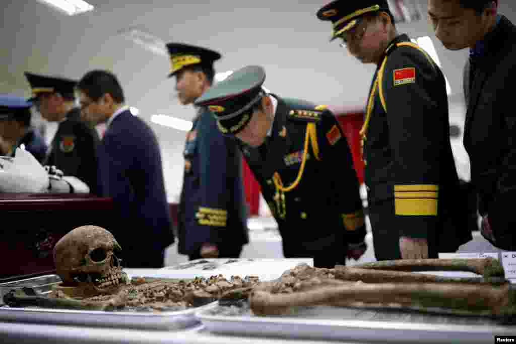 Chinese military officials look at the remains of a Chinese soldier who fought in the Korean War, during the coffin rites in Incheon, South Korea.