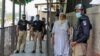 Security personnel, left and right, stand outside the district court building following the killing of a man allegedly accused of blasphemy in Peshawar on July 29, 2020.