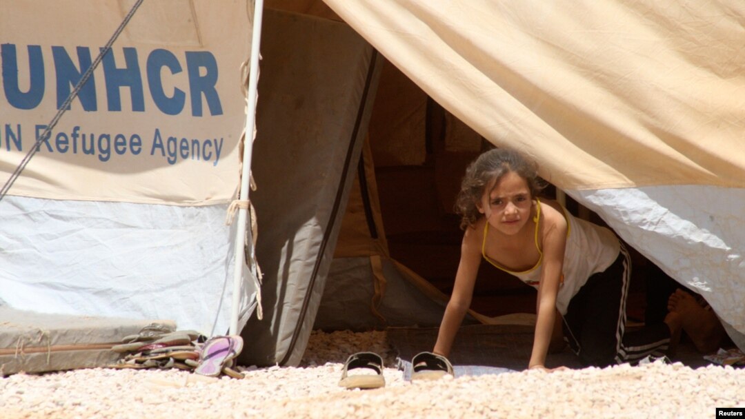 Seorang anak perempuan mengamati dari tenda penampungannya di Al Zaatri dekat kota Mafraq, Jordania dekat perbatasan dengan Suriah (Foto: dok). 