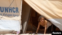 Seorang anak perempuan menampakkan diri dari tenda pengungsi Al Zaatri di kota Mafraq, dekat perbatasan Suriah (Foto: dok). Menurut badan pengungsi PBB (UNHCR), jumlah pengungsi Suriah sekarang sudah mencapai satu juta orang, Rabu (6/3).