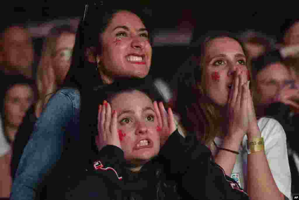 English supporters react while watching the game during extra time at a fan zone in Manchester, England, July, 11, 2021 during the Euro 2020 soccer championship final match between England and Italy at Wembley Stadium in London. 