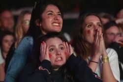 English supporters react while watching the game during extra time at a fan zone in Manchester, England, July, 11, 2021 during the Euro 2020 soccer championship final match between England and Italy at Wembley Stadium in London.