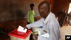 FILE - A man casts his ballot during elections in Bangui, Central African Republic, Dec. 30, 2015. The nation's top court has annulled the legislative elections and approved a presidential runoff vote.