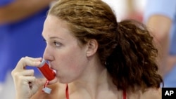 FILE - U.S. swimmer Shannon Vreeland uses an inhaler during a practice session ahead of the 2012 Summer Olympics, in London, July 26, 2012.