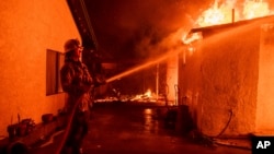 ARCHIVO - Un bombero riega con agua una estructura afectadas por los incendios en Altadena, California, el 8 de enero de 2025. México anunció el despliegue de expertos para ayudar a paliar la crisis en esa región.