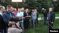 Russia's President Vladimir Putin (R) talks to journalists in the far eastern city of Vladivostok, Aug. 31, 2013. 