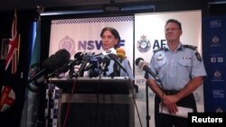 FILE - Australian Federal Police Deputy Commissioner Michael Phelan (R) listens as New South Wales Deputy Police Commissioner Catherine Burn speaks during a media conference in Sydney, Feb. 11, 2015.