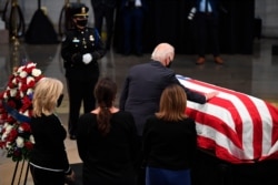 El candidato presidencial demócrata y exvicepresidente de EE.UU., Joe Biden, junto a su esposa Jill Biden, toca el ataúd del fallecido ícono de los derechos civiles John Lewis, en el capitolio en Washington, el lunes 27 de julio de 2020.