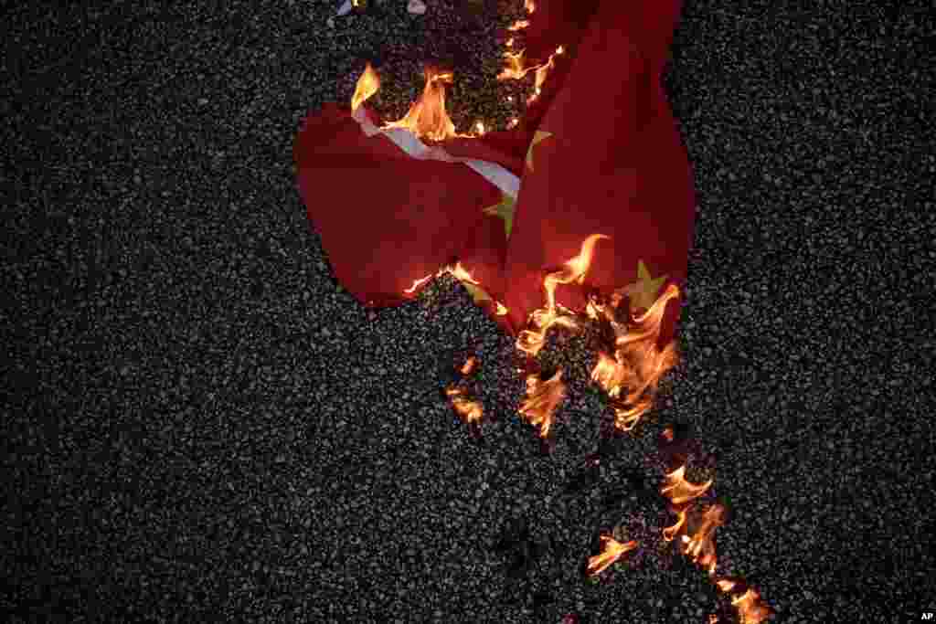 A Chinese national flag burns on the road in Hong Kong.