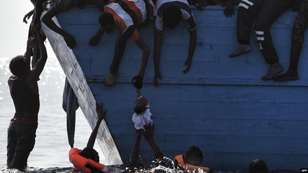 Para migran berupaya menyelamatkan seorang bocah yang tercebur ke laut, sementara mereka menunggu kedatangan regu penyelamat di laut Mediterania, sekitar 12 mil laut sebelah utara dari Libya, 4 Oktober 2016. (Foto: dok).