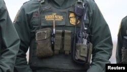 U.S. Customs and Border Patrol agents watch as President Donald Trump visits the banks of the Rio Grande River in Mission, Texas, Jan. 10, 2019. 