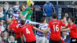 Manchester United's goalkeeper David De Gea catches the ball under pressure from Queens Park Rangers Dudley Campbell, below, during their English Premier League soccer match at Loftus Road stadium in London, Sunday, Dec. 18, 2011. (AP Photo/Alastair Gran