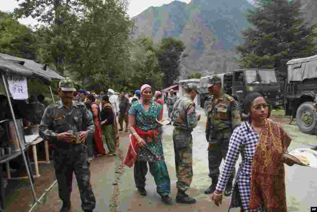 Indian army personnel distribute free food to stranded pilgrims after they were rescued from one of the worst flood affected regions in Govind Ghat, in the northern Indian state of Uttarakhand, June 18, 2013.