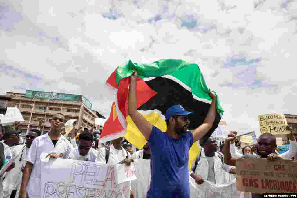 Um membro da comunidade médica exibe a bandeira de Moçambique na marcha em Maputo contra a violação dos direitos humanos e falta de democracia no país