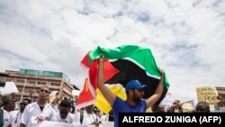 Um membro da comunidade médica exibe a bandeira de Moçambique na marcha em Maputo contra a violação dos direitos humanos e falta de democracia no país