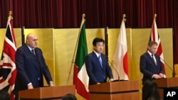 FILE - Britain's Defense Minister Grant Shapps, right, Italy's Defense Minister Guido Crosetto, left, and Japanese Defense Minister Minoru Kihara on Dec. 14, 2023, in Tokyo, Japan. Japan’s Cabinet approved a plan to sell fighter jets being developed with Britain and Italy.