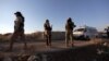 FILE - An ambulance passes by Islamist rebels from Hayat Tahrir al-Sham outside the villages of al-Foua and Kefraya,Syria July 18, 2018. 