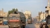 FILE - A Turkish military convoy drives through a town in Syria's northwestern Idlib province, Oct. 20, 2020. An little known Islamist group said it was behind an attack Saturday that targeted a Turkish military outpost in the province.