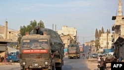 FILE - A Turkish military convoy drives through a town in Syria's northwestern Idlib province, Oct. 20, 2020. An little known Islamist group said it was behind an attack Saturday that targeted a Turkish military outpost in the province.