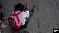 Devojčica koja ide ka granici sa Amerikom iz Meksika sa roditeljima koji planiraju da traže azil (Foto: Yuri CORTEZ / AFP)