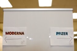 Signs and age groups are shown for the Pfizer and Moderna vaccines at a vaccination center in Chula Vista, California, April 15, 2021.