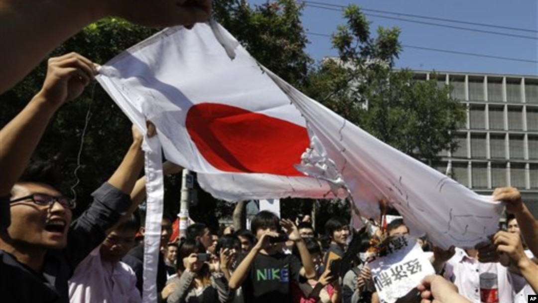 Demonstran Tiongkok membakar bendera Jepang dalam aksi protes anti Jepang di depan Kedutaan Jepang di Beijing (15/9).