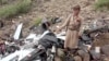 A man points as he stands in the site of the wreckage of a U.S. MQ-9 drone that Houthis claim they shot out of the sky, in a location given as Saada Governorate, Yemen, in this undated screengrab taken from a video obtained by Reuters Aug. 4, 2024. 