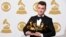 Sam Smith poses in the press room with the awards for best new artist, best pop vocal album for “In the Lonely Hour”, song of the year for “Stay With Me”, and record of the year for “Stay With Me” at the 57th annual Grammy Awards at the Staples Center on 