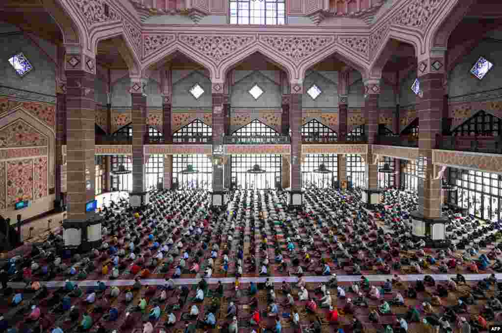 ملائیشیا کے شہر پتراجایا کی ایک مسجد میں لوگ ایک دوسرے سے فاصلہ رکھ کر نمازِ جمعہ ادا کر رہے ہیں۔