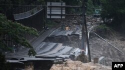 Jalanan yang rusak akibat hujan lebat di kawasan Kuma, Prefektur Kumamoto, Jepang, 7 Juli 2020.