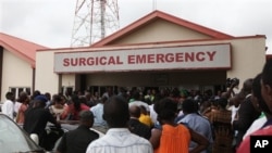 Family members and friends gather at the entrance of the Surgical and Emergency Lagos state university teaching hospital where survivals of a plane crash receive treatment in Lagos.